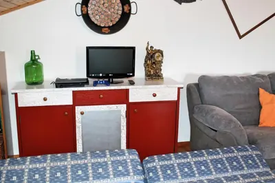 a living room with a red cabinet with a tv on it at OurMadeira - Casa Jardim Mar in Ponta do Sol