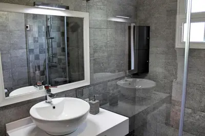 a bathroom with a white sink and a shower at OurMadeira - Casa Jardim Mar in Ponta do Sol