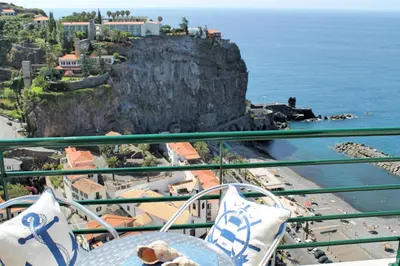 a table and chairs with a view of the ocean at OurMadeira - Casa Jardim Mar in Ponta do Sol