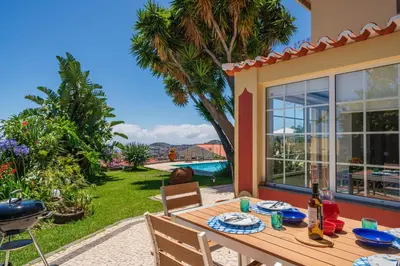 a patio with a table and chairs and a pool at OurMadeira - Quinta D'Alegria in Funchal