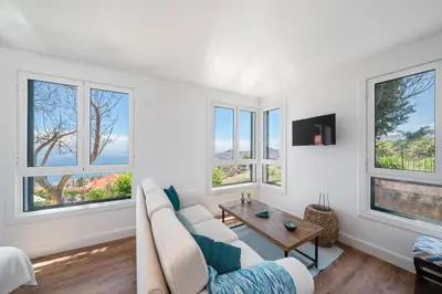 a living room with a couch and windows at OurMadeira - Quinta D'Alegria in Funchal