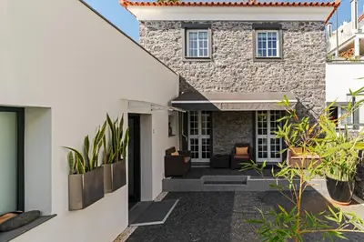 a home with a stone facade and plants at OurMadeira - Grayci's House in Arco da Calheta