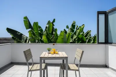 a table and chairs on a balcony with plants at OurMadeira - Grayci's House in Arco da Calheta