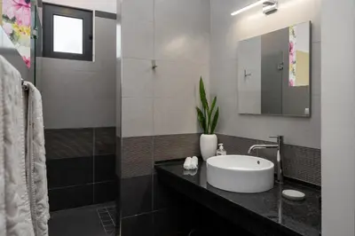 a bathroom with a sink and a mirror at OurMadeira - Grayci's House in Arco da Calheta