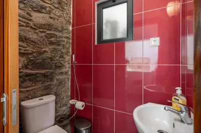 a bathroom with a toilet and a sink and a mirror at OurMadeira - Grayci's House in Arco da Calheta