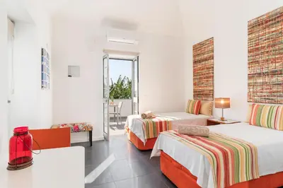 a hotel room with two beds and a table at OurMadeira - Grayci's House in Arco da Calheta