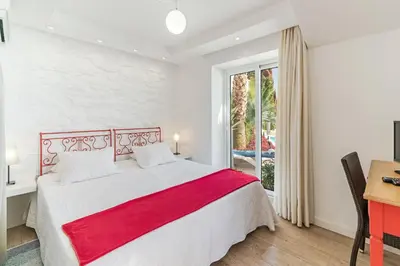 a bedroom with a bed and a desk and a window at OurMadeira - Villa do Mar II in Arco da Calheta