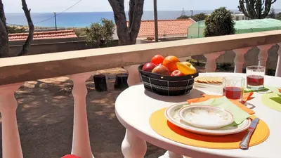 a table with a basket of fruit on a balcony at OurMadeira - Villa Mary in Porto Santo
