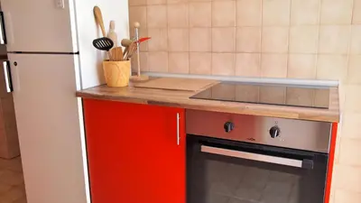 a kitchen with a red stove and a refrigerator at OurMadeira - Villa Mary in Porto Santo