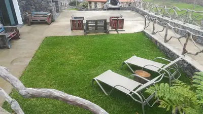 two white chairs sitting on the grass in a yard at Refúgio da Xamusca in São Vicente