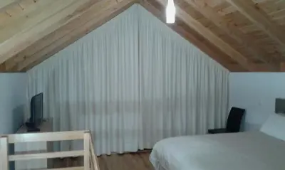 a bedroom with a bed and a window with curtains at Refúgio da Xamusca in São Vicente