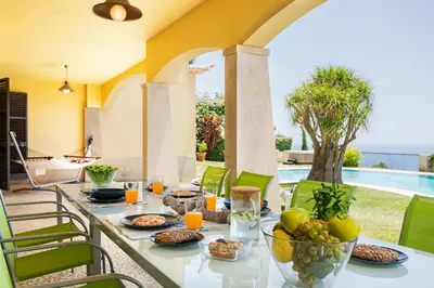 a table with food and fruit on a patio at Vila Eucalipto by An Island Apart in Funchal
