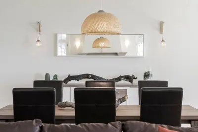 a dining room with a table with chairs and a mirror at Vila Eucalipto by An Island Apart in Funchal