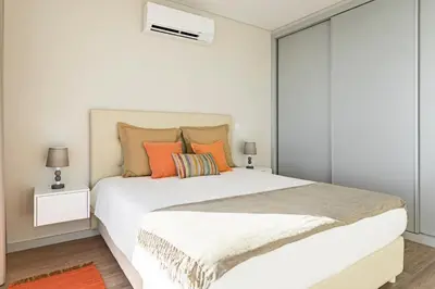 a bedroom with a large white bed with orange pillows at Searenity Vacation Home I by An Island Apart in Arco da Calheta