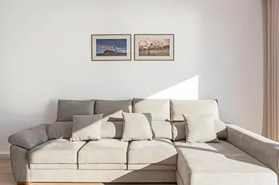 a white couch in a living room with two pictures on the wall at Searenity Vacation Home I by An Island Apart in Arco da Calheta