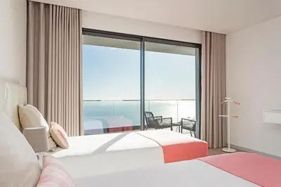 a hotel room with two beds and a large window at Searenity Vacation Home I by An Island Apart in Arco da Calheta