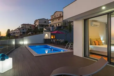 a house with a swimming pool and a bedroom at Searenity Vacation Home I by An Island Apart in Arco da Calheta
