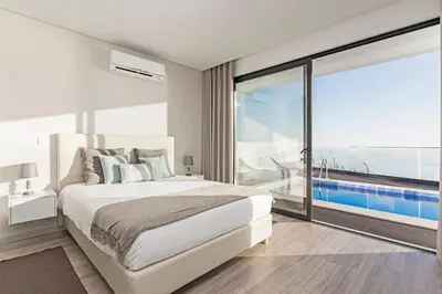 a bedroom with a large bed and a large window at Searenity Vacation Home II by An Island Apart in Arco da Calheta