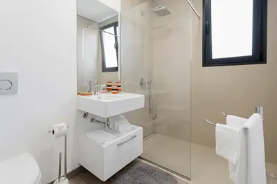 a white bathroom with a sink and a shower at Searenity Vacation Home II by An Island Apart in Arco da Calheta