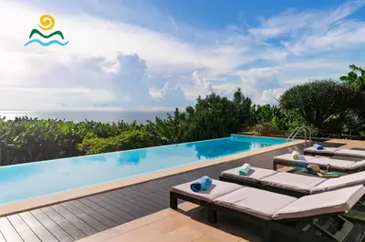 a resort pool with lounge chairs and the ocean at OurMadeira - The Designhouse in Arco da Calheta