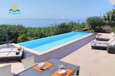 a villa with a swimming pool and a view of the ocean at OurMadeira - The Designhouse in Arco da Calheta