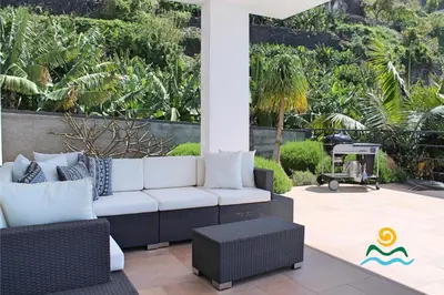 a patio with a white couch and a grill at OurMadeira - The Designhouse in Arco da Calheta