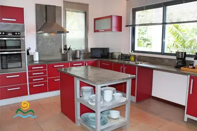 a kitchen with red cabinets and a island in it at OurMadeira - The Designhouse in Arco da Calheta