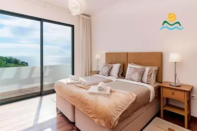 a bedroom with a large bed and a large window at OurMadeira - The Designhouse in Arco da Calheta