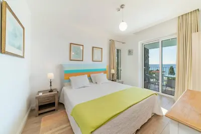 a bedroom with a large bed and a balcony at OurMadeira - Villa do Mar III in Arco da Calheta