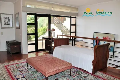 a bedroom with a bed and a table and chairs at OurMadeira - Villa Luz in Funchal