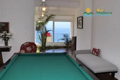 a pool table in a living room with a view of the ocean at OurMadeira - Casa do Júlio in Calheta