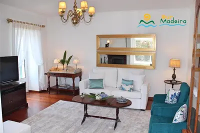 a living room with a white couch and a table at OurMadeira - Casa do Júlio in Calheta