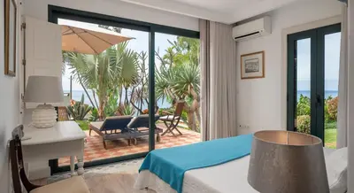 a bedroom with a bed and a view of the ocean at OurMadeira - Villa do Mar I in Arco da Calheta