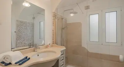 a bathroom with a sink and a shower and a mirror at OurMadeira - Villa do Mar I in Arco da Calheta