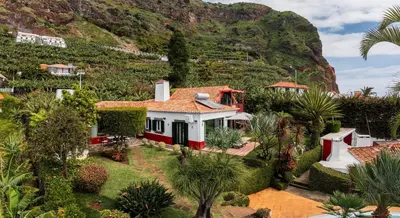 a house with a mountain in the background at OurMadeira - Villa do Mar I in Arco da Calheta