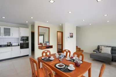 a kitchen and a dining room with a table and chairs at OurMadeira - Casa Amaro Mar in Arco da Calheta