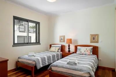 a bedroom with two beds and a window at OurMadeira - Casa Amaro Mar in Arco da Calheta
