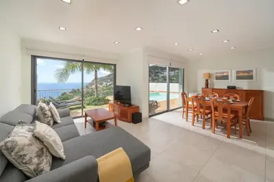 a living room with a couch and a table with a dining room at OurMadeira - Casa Amaro Mar in Arco da Calheta