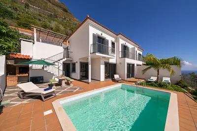 an exterior view of a house with a swimming pool at OurMadeira - Casa Amaro Mar in Arco da Calheta
