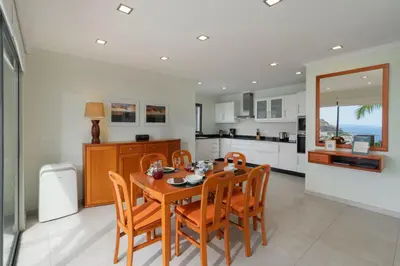 a kitchen and dining room with a wooden table and chairs at OurMadeira - Casa Amaro Mar in Arco da Calheta