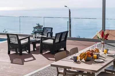 a table with a bowl of fruit on top of a roof at OurMadeira - Vila da Portada in Funchal