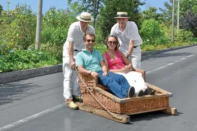 a group of people pulling a man on a wagon at OurMadeira - Vila da Portada in Funchal