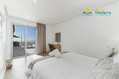 a bedroom with a bed and a view of the ocean at OurMadeira - Calheta Heights in Calheta