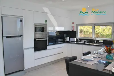 a kitchen with white appliances and a table with a dining room at OurMadeira - Calheta Heights in Calheta
