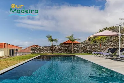 a swimming pool in a villa with a stone wall at OurMadeira - Calheta Heights in Calheta