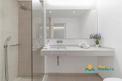 a white bathroom with a sink and a shower at OurMadeira - Calheta Heights in Calheta