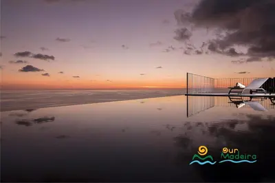 a pool of water with a sunset in the background at OurMadeira - Cliffscape in Estreito da Calheta