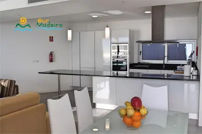 a kitchen with a table with a bowl of fruit on it at OurMadeira - Cliffscape in Estreito da Calheta