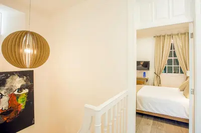 a bedroom with a bed and a pendant light at Cayres Suites Surdo in Funchal