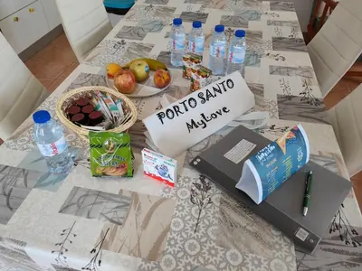 a table with a laptop and a bowl of fruit and water at PORTO SANTO MyLove in Porto Santo